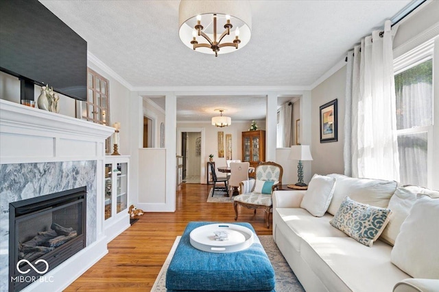 744 Gilbert Ave, Indianapolis, IN 46227 - living area with a chandelier, wood finished floors, a textured ceiling, ornamental molding, and a high end fireplace