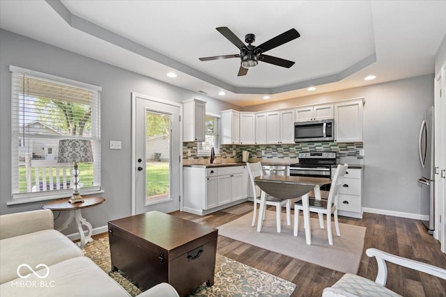 744 Gilbert Ave, Indianapolis, IN 46227 - living area featuring a tray ceiling, a ceiling fan, dark wood-style floors, recessed lighting, and baseboards