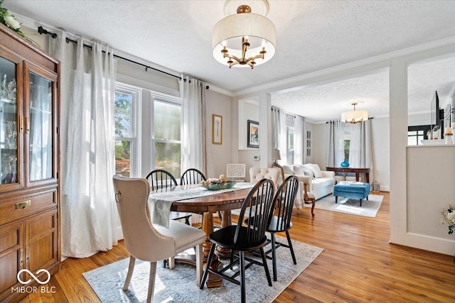 744 Gilbert Ave, Indianapolis, IN 46227 - dining area featuring a chandelier, a textured ceiling, plenty of natural light, light wood-type flooring, and ornamental molding