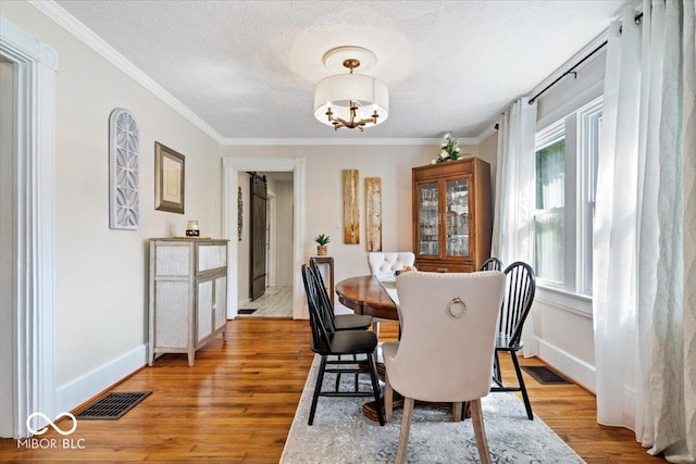 744 Gilbert Ave, Indianapolis, IN 46227 - dining space with a chandelier, wood finished floors, a textured ceiling, ornamental molding, and baseboards
