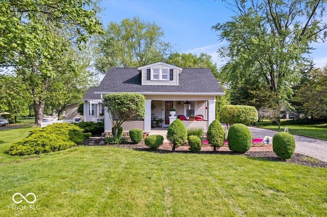 744 Gilbert Ave, Indianapolis, IN 46227 - bungalow-style home featuring covered porch, a front lawn, and roof with shingles