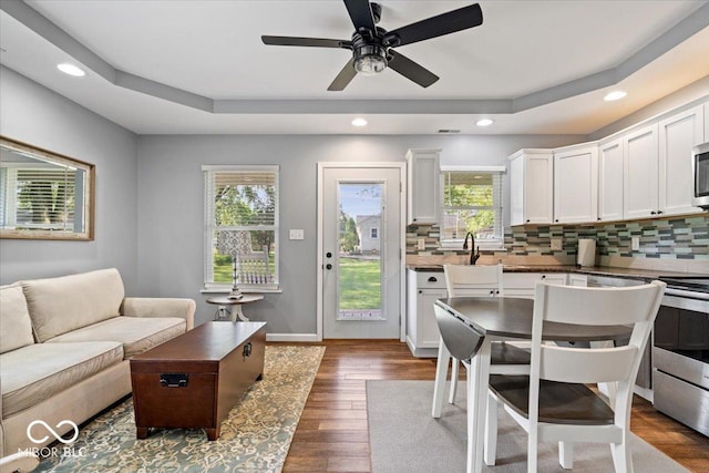 744 Gilbert Ave, Indianapolis, IN 46227 - living room featuring ceiling fan, a tray ceiling, recessed lighting, wood finished floors, and baseboards