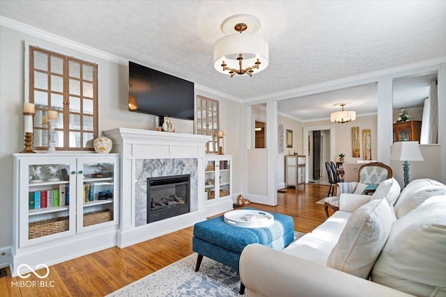 744 Gilbert Ave, Indianapolis, IN 46227 - living area with a chandelier, wood finished floors, a premium fireplace, ornamental molding, and a textured ceiling