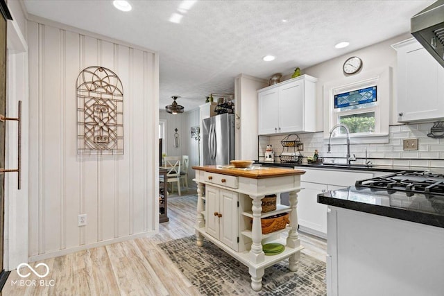 744 Gilbert Ave, Indianapolis, IN 46227 - kitchen with a sink, light wood-style floors, white cabinetry, wood counters, and open shelves