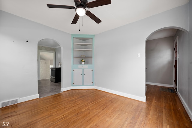 6851 W County Road 550 S, Daleville, IN 47334 - empty room with built in features, a ceiling fan, arched walkways, and hardwood / wood-style flooring