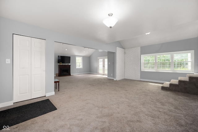 6851 W County Road 550 S, Daleville, IN 47334 - unfurnished living room featuring a fireplace, vaulted ceiling, carpet flooring, and baseboards