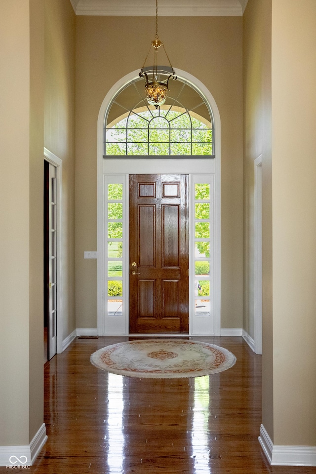 3107 Waterfront Cir, Anderson, IN 46012 - foyer with wood finished floors, baseboards, ornamental molding, a towering ceiling, and a chandelier
