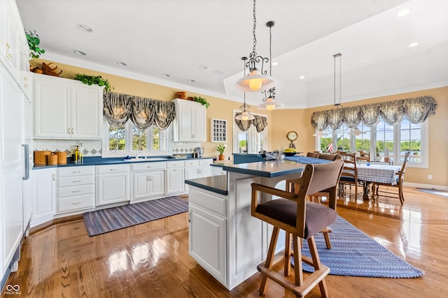 3107 Waterfront Cir, Anderson, IN 46012 - kitchen with healthy amount of natural light, dark countertops, a breakfast bar area, a kitchen island, and recessed lighting