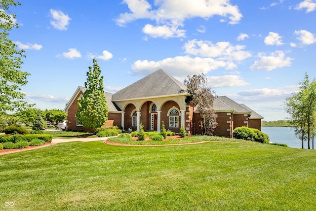 3107 Waterfront Cir, Anderson, IN 46012 - view of front facade featuring a front lawn, brick siding, a water view, and a shingled roof
