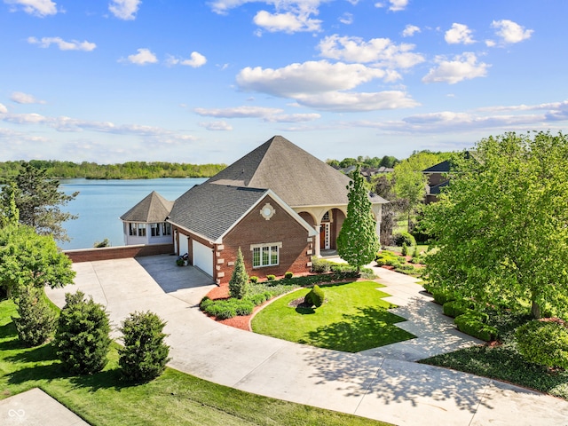 3107 Waterfront Cir, Anderson, IN 46012 - view of front facade with concrete driveway, brick siding, an attached garage, a front yard, and a water view
