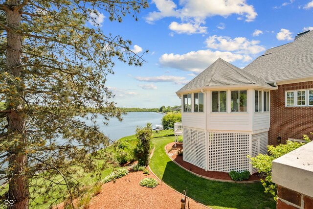 3107 Waterfront Cir, Anderson, IN 46012 - view of side of property featuring a water view, a shingled roof, a lawn, brick siding, and a sunroom