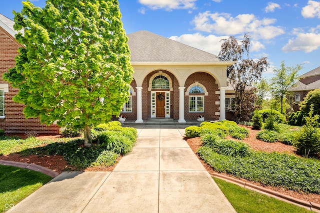 3107 Waterfront Cir, Anderson, IN 46012 - property entrance with brick siding, roof with shingles, and a porch