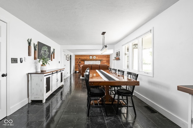 dining space with baseboards, granite tiled floors, and a textured ceiling
