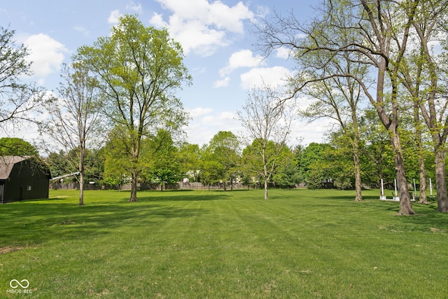 view of green lawn featuring a barn and an outbuilding