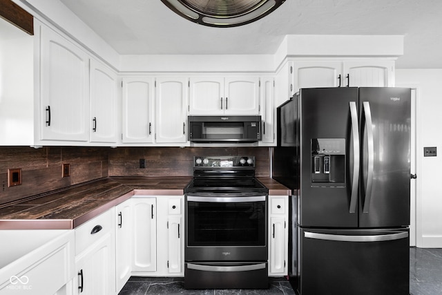 kitchen with refrigerator with ice dispenser, stainless steel electric range oven, dark countertops, and white cabinetry