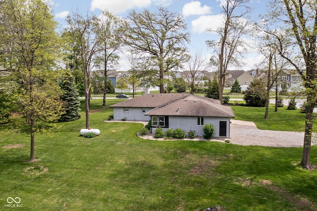 view of front of property with a front yard, a residential view, a shingled roof, and stucco siding