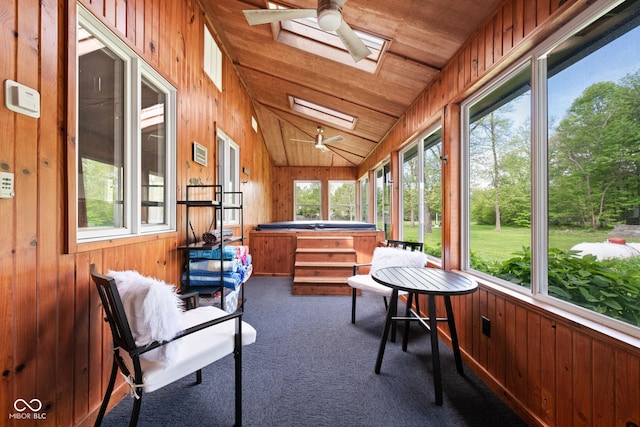 sunroom / solarium featuring a jacuzzi, a ceiling fan, a skylight, plenty of natural light, and vaulted ceiling