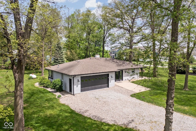 view of front facade with gravel driveway, roof with shingles, a front yard, and a garage