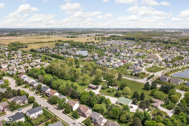 aerial view of property and surrounding area with nearby suburban area and a large body of water