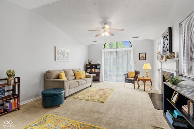 carpeted living room with ceiling fan, baseboards, lofted ceiling, and a textured ceiling