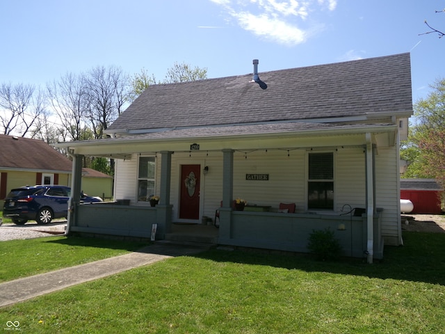 bungalow-style house featuring a porch, a shingled roof, and a front lawn