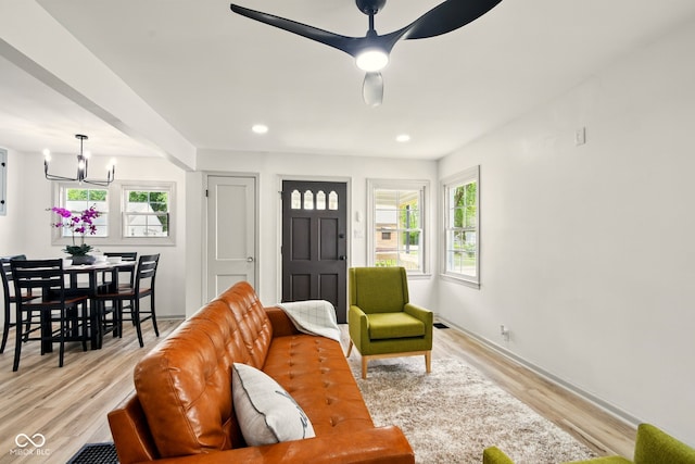 living area with a chandelier, plenty of natural light, light wood finished floors, recessed lighting, and a ceiling fan