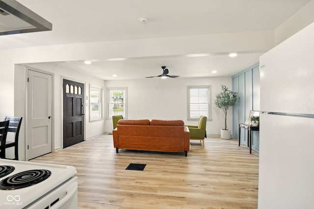 living room with light wood-style floors, a ceiling fan, plenty of natural light, recessed lighting, and baseboards