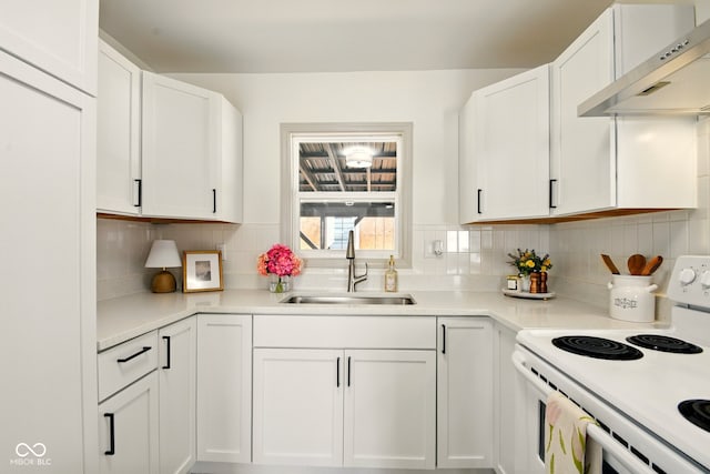 kitchen featuring white electric range, extractor fan, a sink, white cabinets, and backsplash