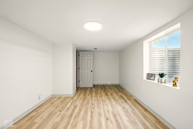 empty room featuring light wood finished floors and baseboards