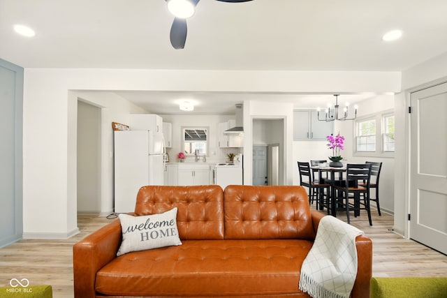 living room featuring a chandelier, light wood-style floors, baseboards, recessed lighting, and ceiling fan
