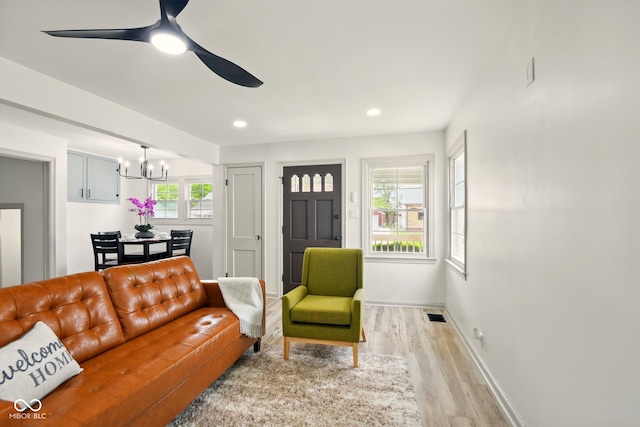 living area featuring light wood-type flooring, a chandelier, baseboards, ceiling fan, and recessed lighting