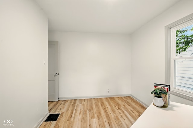 unfurnished room with light wood-style floors and baseboards