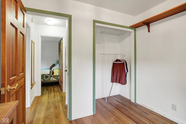 hall with light wood-type flooring and baseboards