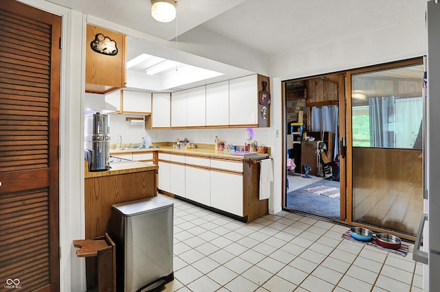 kitchen featuring white cabinetry, a sink, and light tile patterned flooring