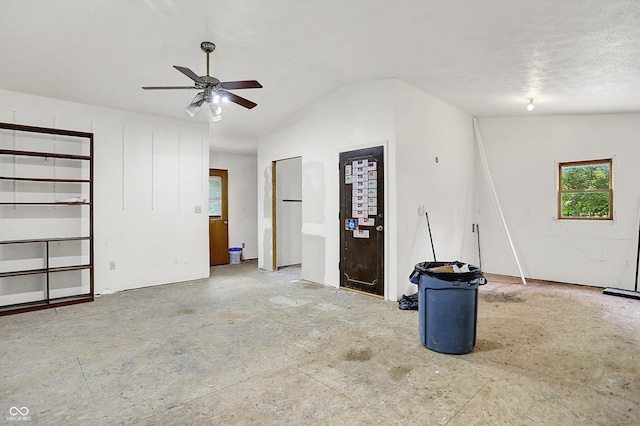 unfurnished living room featuring healthy amount of natural light, a ceiling fan, and vaulted ceiling