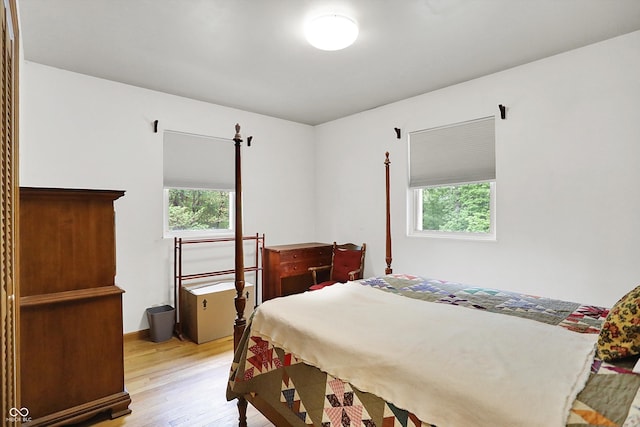 bedroom with multiple windows and light wood finished floors