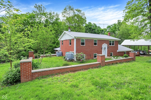 bi-level home with a chimney, a front lawn, brick siding, and central AC