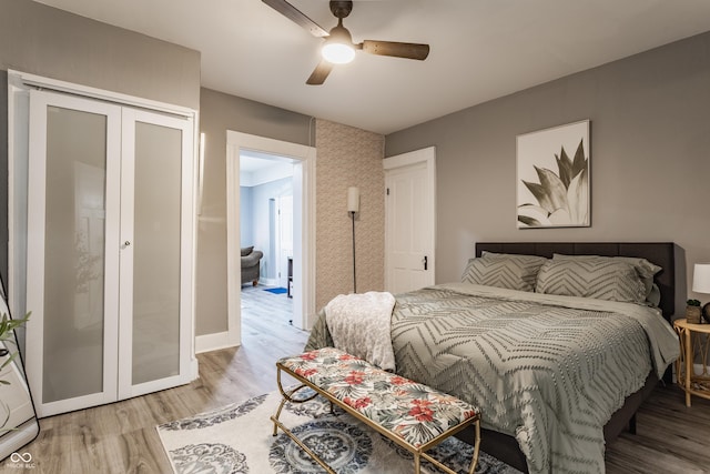 bedroom featuring light wood-style flooring, ceiling fan, and a closet