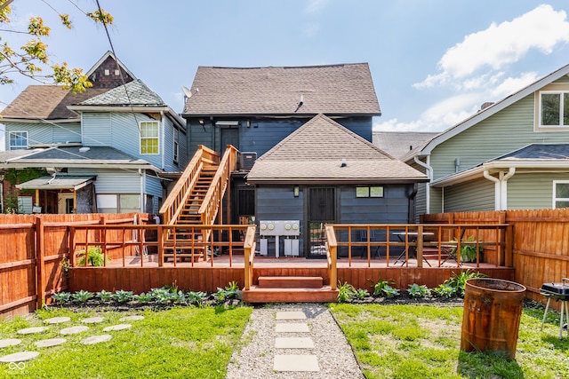 rear view of property featuring a wooden deck and roof with shingles