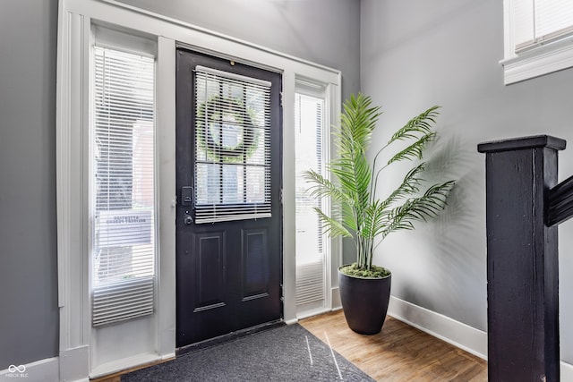 foyer featuring baseboards and wood finished floors