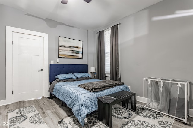 bedroom featuring wood finished floors, a ceiling fan, and baseboards