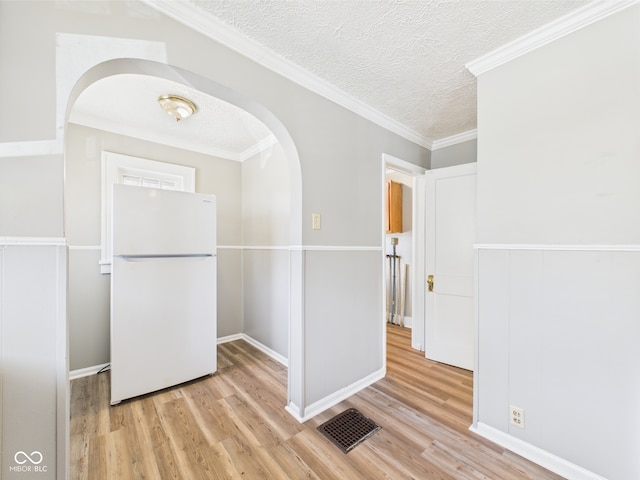 3631 Columbus Ave, Anderson, IN 46013 - empty room with light wood-style floors, a textured ceiling, arched walkways, baseboards, and ornamental molding