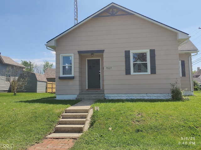 bungalow with entry steps and a front lawn