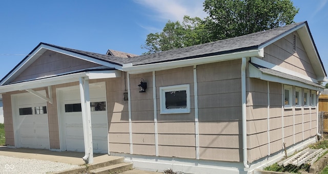 view of front facade with a garage and roof with shingles