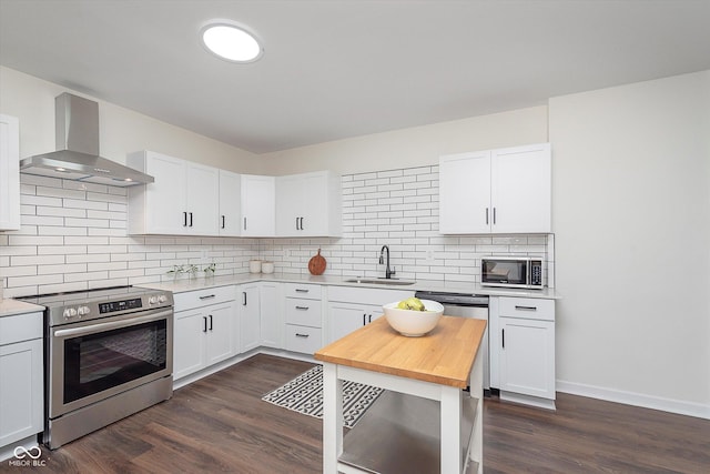 2442 Guilford Ave, Indianapolis, IN 46205 - kitchen with stainless steel appliances, wall chimney exhaust hood, a sink, dark wood-type flooring, and decorative backsplash