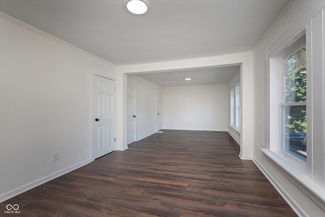 2442 Guilford Ave, Indianapolis, IN 46205 - empty room featuring dark wood-style floors, baseboards, and crown molding