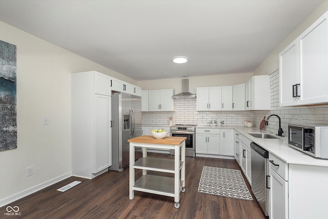 2442 Guilford Ave, Indianapolis, IN 46205 - kitchen featuring appliances with stainless steel finishes, wall chimney exhaust hood, a sink, and dark wood-style floors