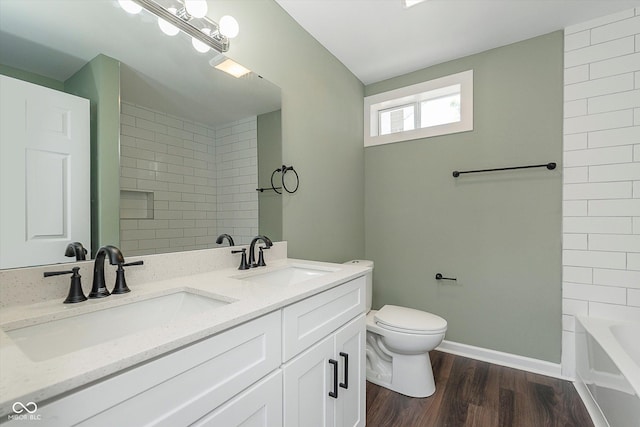 2442 Guilford Ave, Indianapolis, IN 46205 - bathroom with toilet, wood finished floors, baseboards, and double vanity