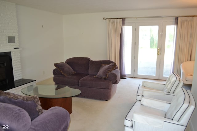 living area featuring carpet flooring, plenty of natural light, and a fireplace
