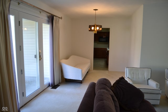 bedroom with multiple windows, a chandelier, and light carpet